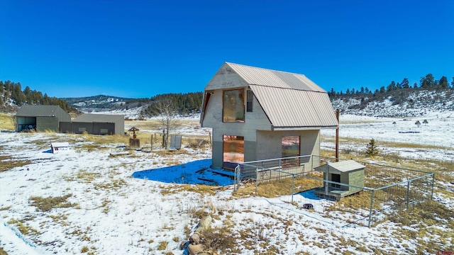 snow covered structure with a mountain view and an outdoor structure