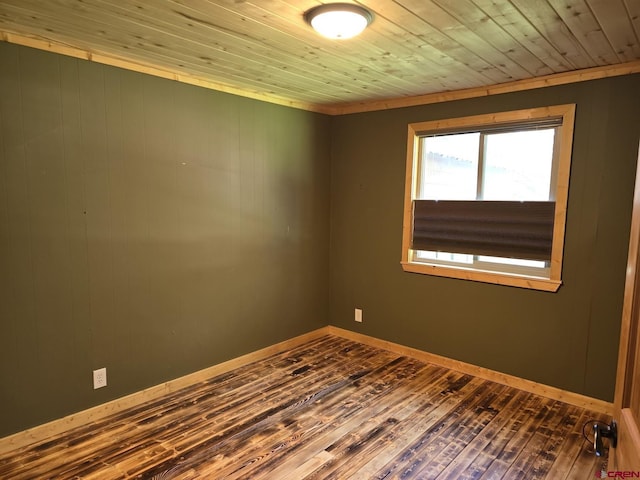 empty room featuring wooden ceiling, dark wood-style floors, and baseboards