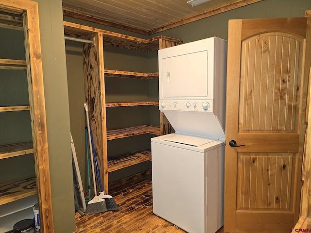 washroom with laundry area, stacked washer / dryer, and wood finished floors