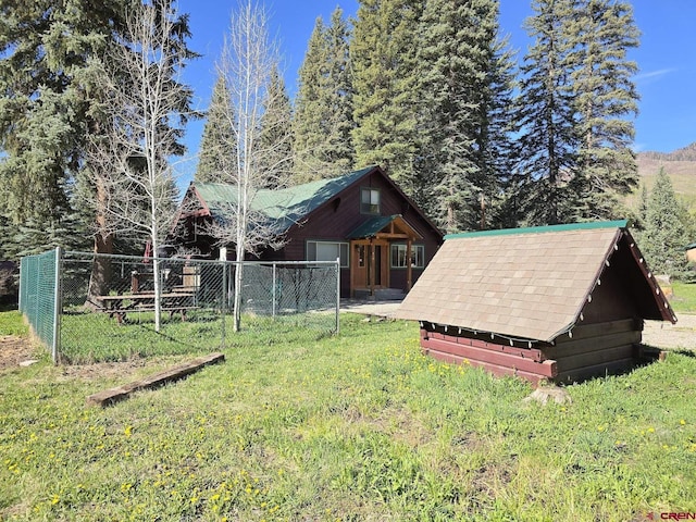 view of yard featuring a storage shed, an outdoor structure, and fence