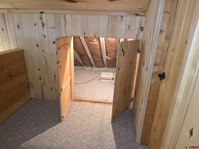 hall with carpet and wood walls