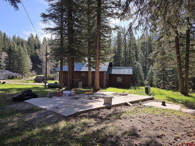 exterior space featuring an outdoor structure and a view of trees