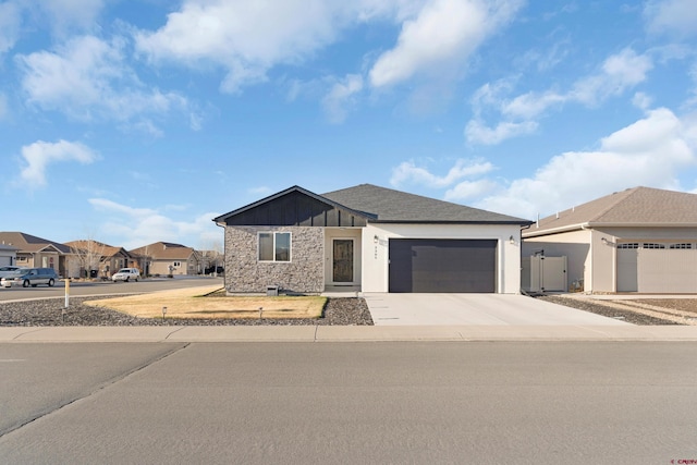 2305 Mountain Pines Dr, Montrose, CO 81401 - view of front of house featuring a residential view, driveway, stone siding, and an attached garage