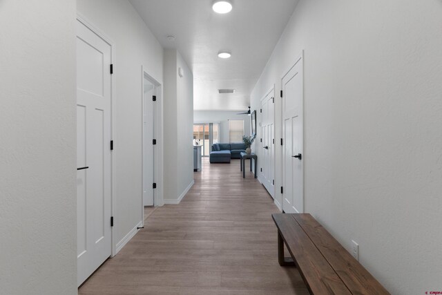 2305 Mountain Pines Dr, Montrose, CO 81401 - corridor with baseboards, visible vents, and wood finished floors