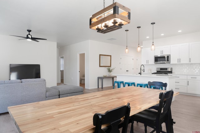 2305 Mountain Pines Dr, Montrose, CO 81401 - dining space with visible vents, light wood-style flooring, recessed lighting, and ceiling fan with notable chandelier
