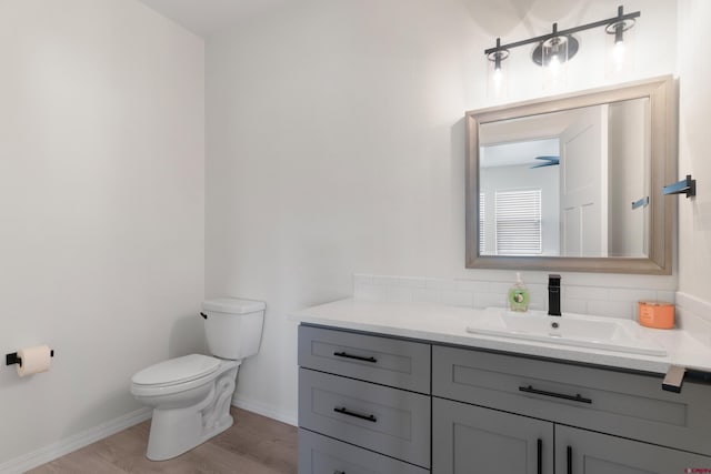 2305 Mountain Pines Dr, Montrose, CO 81401 - bathroom featuring baseboards, wood finished floors, toilet, and vanity