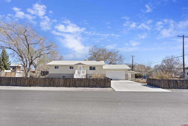 801 S Nevada Ave, Montrose, CO 81401 - view of front of home with metal roof, a fenced front yard, a garage, and concrete driveway