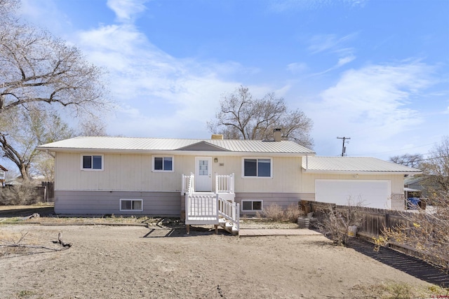 801 S Nevada Ave, Montrose, CO 81401 - view of front of property featuring metal roof, a garage, a chimney, and fence