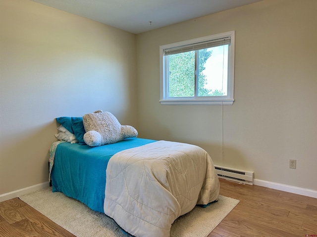 485 1740th Rd, Delta, CO 81416 - bedroom featuring a baseboard heating unit, baseboards, and wood finished floors