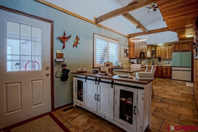 2 S Buffalo Dr, Walsenburg, CO 81089 - kitchen with a peninsula, refrigerator, black microwave, open shelves, and brown cabinetry