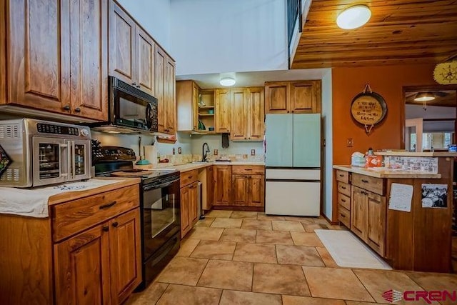 2 S Buffalo Dr, Walsenburg, CO 81089 - kitchen featuring light countertops, black appliances, open shelves, and brown cabinetry