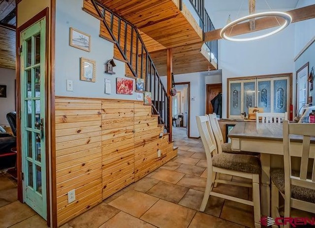 2 S Buffalo Dr, Walsenburg, CO 81089 - dining space with wood walls, stairs, a towering ceiling, an inviting chandelier, and wood ceiling