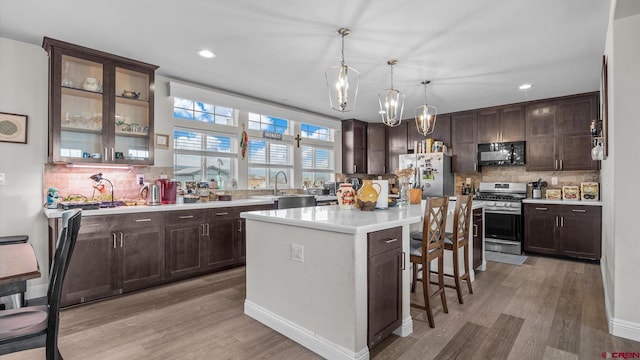 1241 Appaloosa St, Delta, CO 81416 - kitchen featuring light wood-style floors, light countertops, dark brown cabinets, and appliances with stainless steel finishes