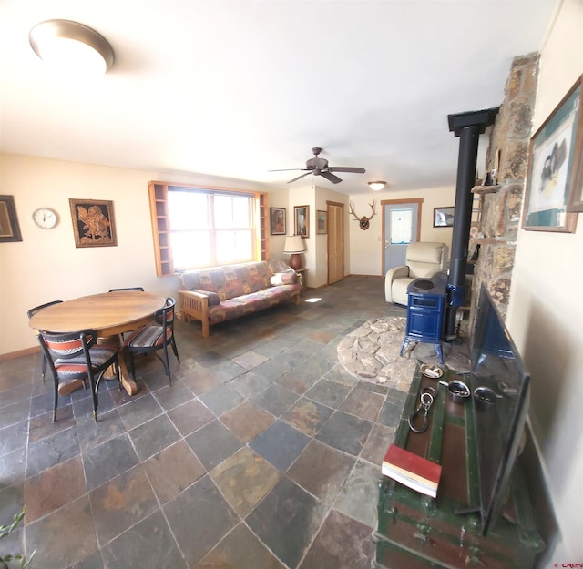 1435 Pine St, Norwood, CO 81423 - living room with a wood stove, a ceiling fan, and stone finish flooring
