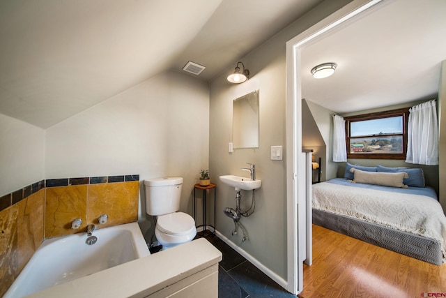 ensuite bathroom featuring a bath, ensuite bath, vaulted ceiling, visible vents, and toilet