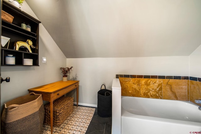 bathroom with a bath and vaulted ceiling