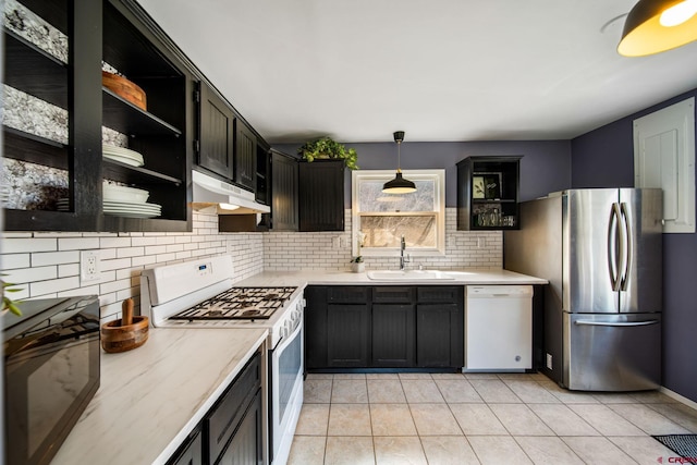 kitchen featuring white appliances, light countertops, open shelves, under cabinet range hood, and a sink