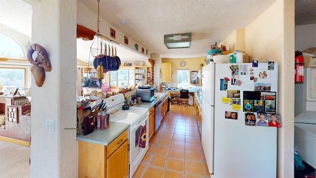 kitchen with light tile patterned floors, light countertops, and white appliances