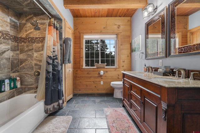 full bath featuring wood walls, a sink, stone tile flooring, wooden ceiling, and toilet