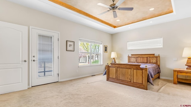 bedroom featuring baseboards, a raised ceiling, light colored carpet, and recessed lighting