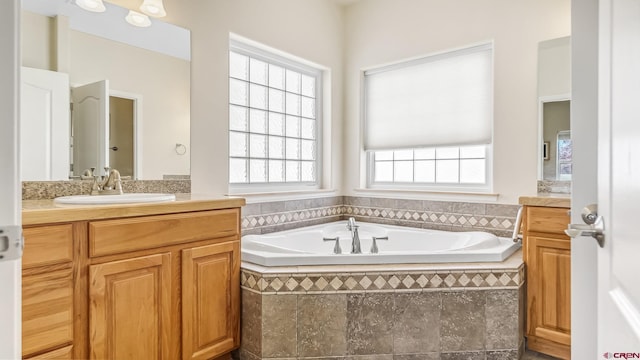 bathroom with a garden tub and vanity