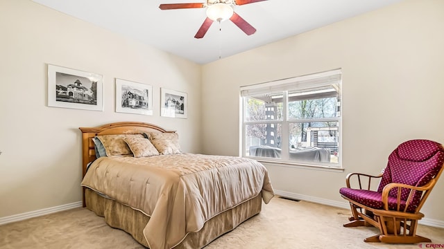 bedroom featuring light carpet, visible vents, baseboards, and ceiling fan