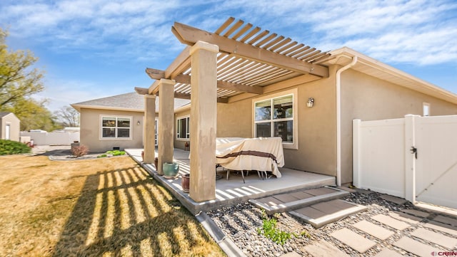 back of house featuring a patio, stucco siding, a gate, a pergola, and fence