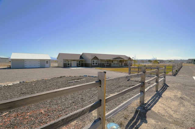 view of front of property featuring an outbuilding, a detached garage, and fence