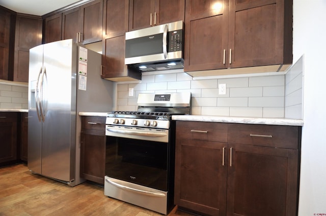 kitchen with tasteful backsplash, light wood finished floors, dark brown cabinetry, and stainless steel appliances