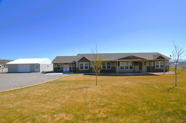 ranch-style home with an outbuilding, a garage, and a front lawn
