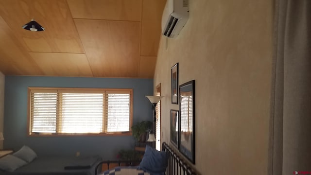 living area with a wall unit AC and lofted ceiling