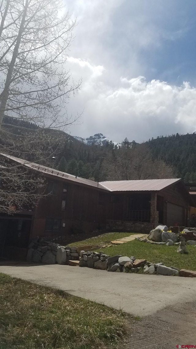 exterior space featuring an attached garage and metal roof