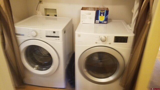 clothes washing area with separate washer and dryer and laundry area