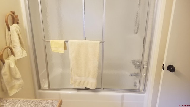 bathroom featuring bath / shower combo with glass door