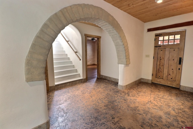 foyer entrance with arched walkways, recessed lighting, wooden ceiling, stairs, and baseboards