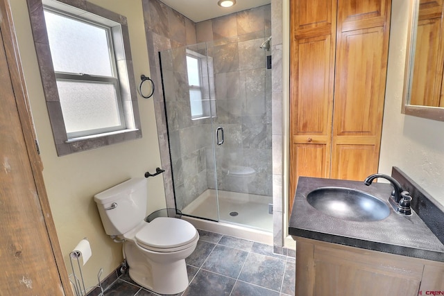 bathroom with toilet, a stall shower, baseboards, and vanity