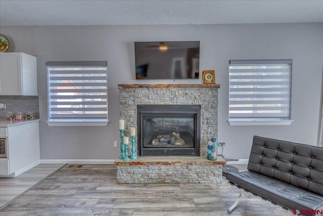 80 Cleek Ct, Pagosa Springs, CO 81147 - living room featuring plenty of natural light, a stone fireplace, baseboards, and wood finished floors