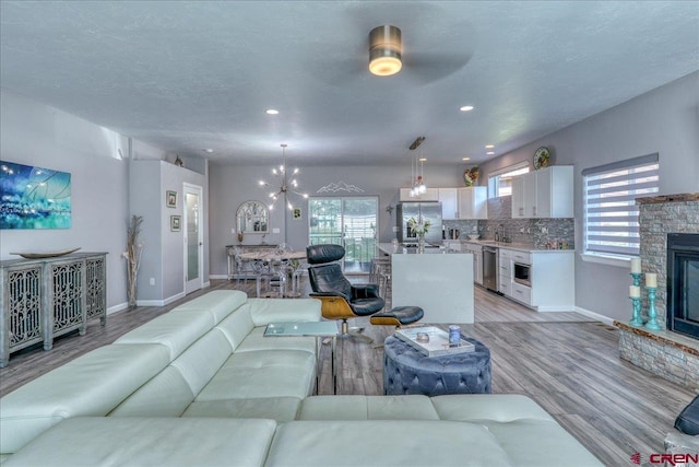80 Cleek Ct, Pagosa Springs, CO 81147 - living room with baseboards, a ceiling fan, a fireplace, light wood finished floors, and recessed lighting