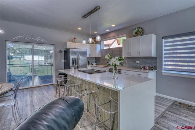 80 Cleek Ct, Pagosa Springs, CO 81147 - kitchen with stainless steel refrigerator with ice dispenser, a center island, light countertops, and white cabinetry