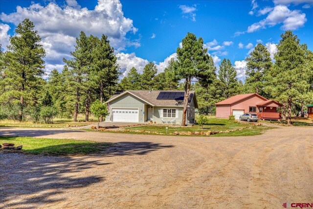 80 Cleek Ct, Pagosa Springs, CO 81147 - view of front of house with driveway, an attached garage, and roof mounted solar panels