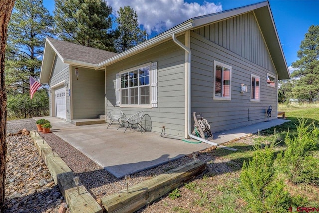 80 Cleek Ct, Pagosa Springs, CO 81147 - rear view of property with an attached garage, a patio, and board and batten siding