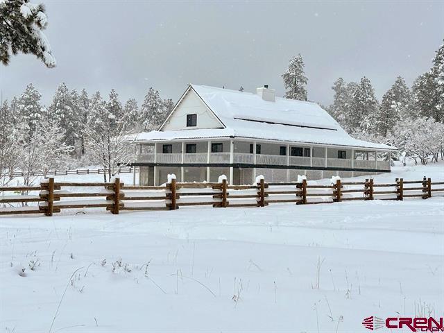 1051 Needles View Pl, Pagosa Springs, CO 81147 - snow covered property featuring fence and a chimney