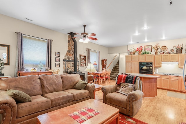 85 Dayspring Pl, Pagosa Springs, CO 81147 - living area featuring light wood-style floors, a wood stove, a ceiling fan, visible vents, and stairs