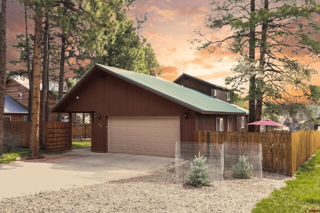 85 Dayspring Pl, Pagosa Springs, CO 81147 - view of front of property featuring concrete driveway, metal roof, an outdoor structure, and fence