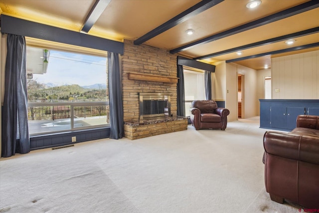 carpeted living area with recessed lighting, visible vents, a mountain view, beam ceiling, and a fireplace