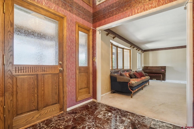 entryway with plenty of natural light, marble finish floor, and baseboards