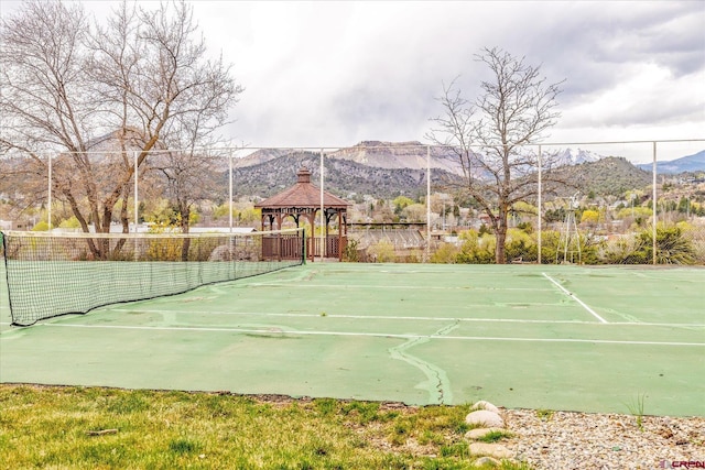 view of sport court with a gazebo, fence, and a mountain view