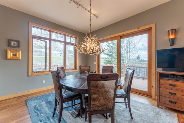 138 Silver Sage Dr, Crested Butte, CO 81224 - dining space with baseboards, wood finished floors, a chandelier, and rail lighting
