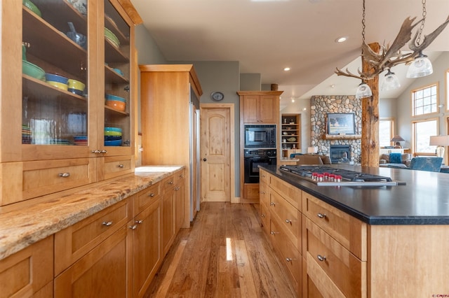 138 Silver Sage Dr, Crested Butte, CO 81224 - kitchen featuring light wood finished floors, black appliances, a fireplace, glass insert cabinets, and open floor plan