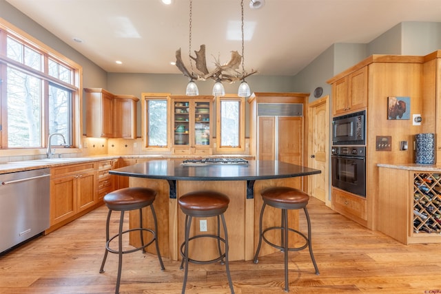 138 Silver Sage Dr, Crested Butte, CO 81224 - kitchen featuring black appliances, a sink, a kitchen island, and light wood-type flooring